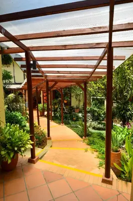 a wooden pergola in a garden with plants at La Campana Hotel Boutique in Medellín