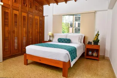 a bedroom with a bed and a window at La Campana Hotel Boutique in Medellín