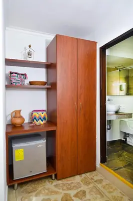 a wooden cabinet in a room with a mirror at La Campana Hotel Boutique in Medellín