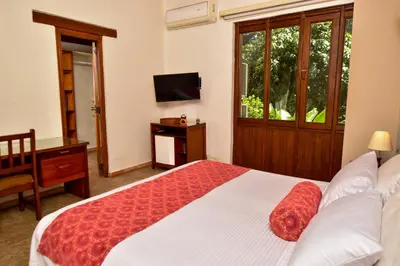 a bedroom with a bed and a desk and a television at La Campana Hotel Boutique in Medellín