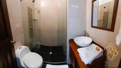 a bathroom with a shower and a toilet and a sink at Hotel Rio Piedras in Jericó
