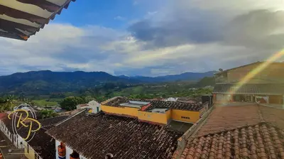 an overhead view of roofs of buildings with a rainbow at Hotel Rio Piedras in Jericó