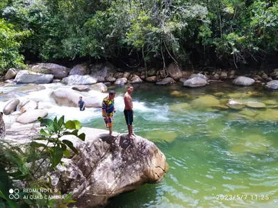 two people standing on a rock in a river at Hotel La Casona - San Luis in San Luis
