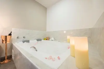 a white bathroom with a tub with a candle at Medellín Vibes in Medellín