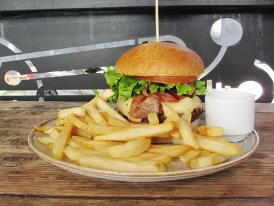 a plate with a sandwich and french fries on a table at Medellín Vibes in Medellín