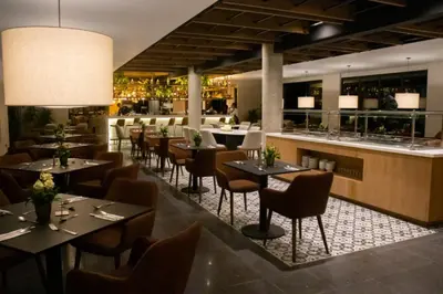 a restaurant with tables and chairs and a bar at Estelar Recinto Del Pensamiento Hotel Y Centro De Convenciones in Manizales