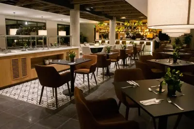 a restaurant with tables and chairs and a bar at Estelar Recinto Del Pensamiento Hotel Y Centro De Convenciones in Manizales