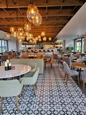 a restaurant with tables and chairs and chandeliers at Estelar Recinto Del Pensamiento Hotel Y Centro De Convenciones in Manizales