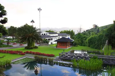 a resort with a pond in front of a building at Estelar Recinto Del Pensamiento Hotel Y Centro De Convenciones in Manizales