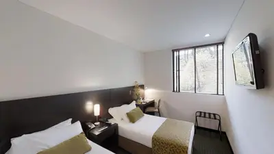 a hotel room with two beds and a television at Estelar Recinto Del Pensamiento Hotel Y Centro De Convenciones in Manizales