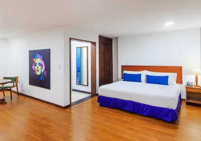 a bedroom with a large bed with blue pillows at Pop Art Hotel Las Colinas Manizales in Manizales