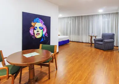a room with a table and chairs and a bedroom at Pop Art Hotel Las Colinas Manizales in Manizales