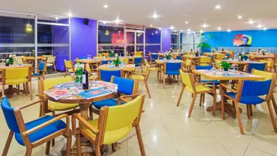a restaurant with wooden tables and blue chairs at Pop Art Hotel Las Colinas Manizales in Manizales