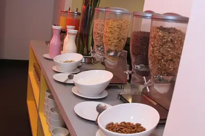 a counter with bowls of cereal and other food at Pop Art Hotel Las Colinas Manizales in Manizales