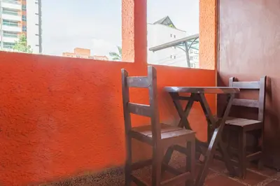 two wooden chairs sitting next to a orange wall at Ayenda Habana Vieja 1221 in Medellín