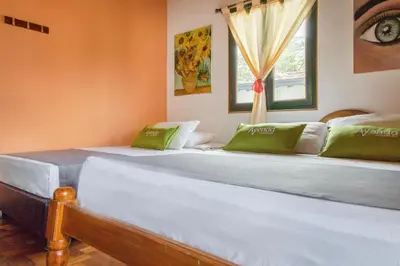 a large white bed in a room with a window at Ayenda Habana Vieja 1221 in Medellín