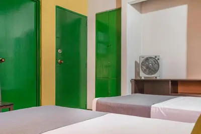 a room with two green doors and a clock at Ayenda Habana Vieja 1221 in Medellín