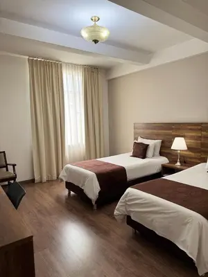 a hotel room with two beds and a window at Hotel Nutibara in Medellín