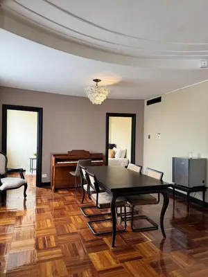a dining room with a table and chairs and a piano at Hotel Nutibara in Medellín