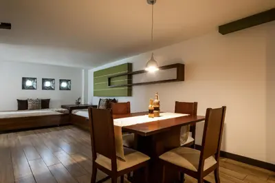 a dining room with a table and chairs and a couch at Hotel Carretero in Manizales