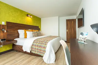 a hotel room with a bed and a desk at Hotel Carretero in Manizales