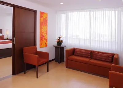 a living room with a couch and two chairs at Hotel Estelar El Cable in Manizales
