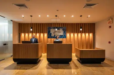 two people sitting at podiums in a lobby at Hotel Holiday Inn Express & Suites Medellin by IHG in Medellín