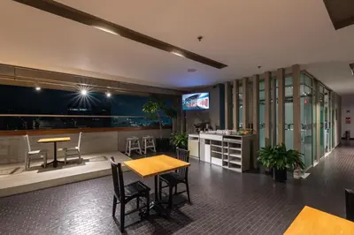 a restaurant with tables and chairs and a tv at Hotel Holiday Inn Express & Suites Medellin by IHG in Medellín