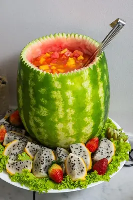 a watermelon bowl filled with soup and fruit on a plate at Hotel Holiday Inn Express & Suites Medellin by IHG in Medellín