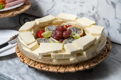 a basket of cheese and fruit on a table at Hotel Holiday Inn Express & Suites Medellin by IHG in Medellín