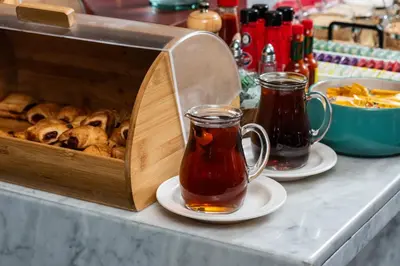 two cups of tea and plates of food on a table at Hotel Holiday Inn Express & Suites Medellin by IHG in Medellín