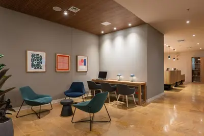 a waiting room with chairs and a table with a laptop at Hotel Holiday Inn Express & Suites Medellin by IHG in Medellín