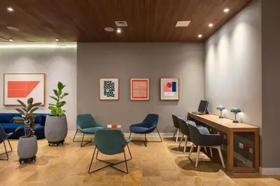 a waiting room with chairs and a table with a laptop at Hotel Holiday Inn Express & Suites Medellin by IHG in Medellín