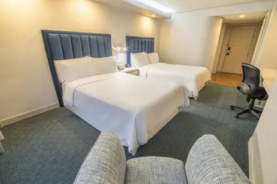 a hotel room with two beds and a couch at Four Points by Sheraton Medellín in Medellín