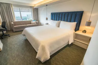 a hotel room with a large bed and a couch at Four Points by Sheraton Medellín in Medellín