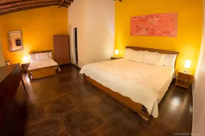 a bedroom with a large bed and yellow walls at 61Prado Hotel in Medellín