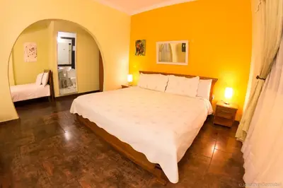 a bedroom with a large bed with yellow walls at 61Prado Hotel in Medellín