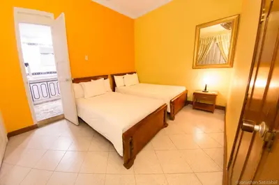 two beds in a room with orange walls at 61Prado Hotel in Medellín