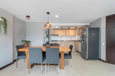 a kitchen and dining room with a wooden table and chairs at Apartamentos Poblado Alejandría by HOUSY in Medellín