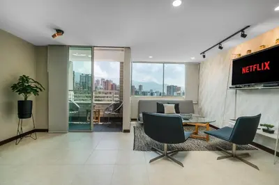 a living room with a tv and a table and chairs at Apartamentos Poblado Alejandría by HOUSY in Medellín