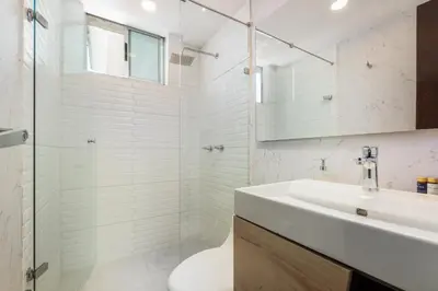 a white bathroom with a sink and a shower at Apartamentos Poblado Alejandría by HOUSY in Medellín