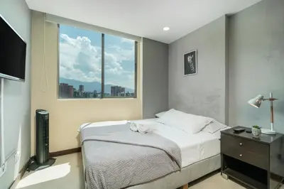 a bedroom with a bed and a window at Apartamentos Poblado Alejandría by HOUSY in Medellín
