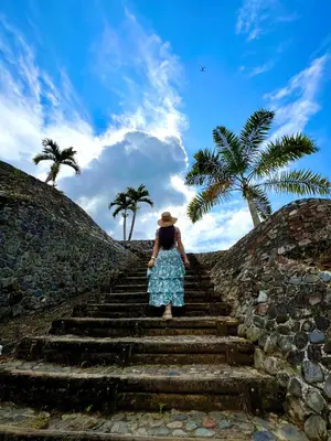 a woman in a hat walking up some stairs at Hotel Campestre la Playa in Betania