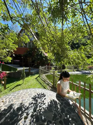 a woman sitting on a bench in a park at Hotel Campestre la Playa in Betania