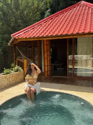a woman is sitting in a swimming pool at Hotel Campestre la Playa in Betania