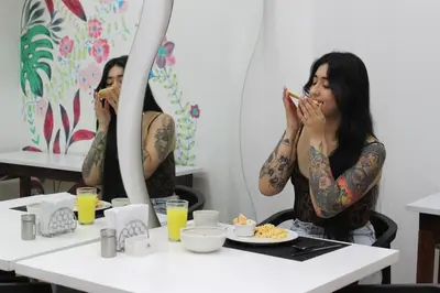 two tattooed women sitting at a table eating food at Hotel Florencia Plaza in Medellín