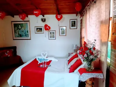 a bedroom with a bed with a red blanket and hearts at Finca Hotel Nutabes in San Pedro