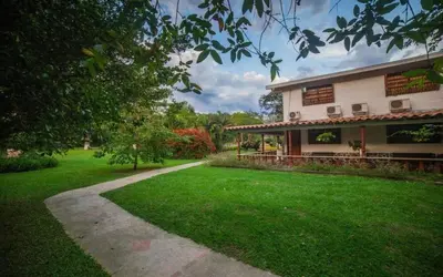 a building with a grass yard next to a building at Hotel San Sebastian del Tonusco in Santa Fe de Antioquia