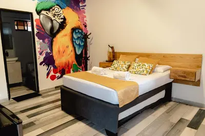 a bedroom with a bed with a painting on the wall at Hotel San Sebastian del Tonusco in Santa Fe de Antioquia