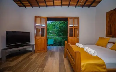 a bedroom with a bed and a tv and a televisionicterictericter at Hotel San Sebastian del Tonusco in Santa Fe de Antioquia